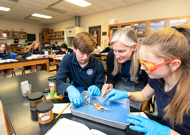 Professor working with students in a science class.